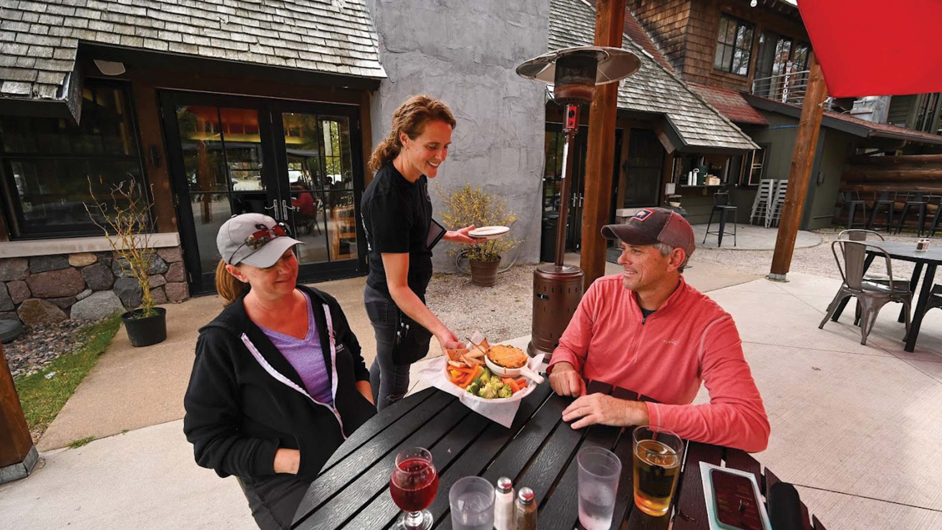 Couple being served food on the patio at Aqualand Ale House