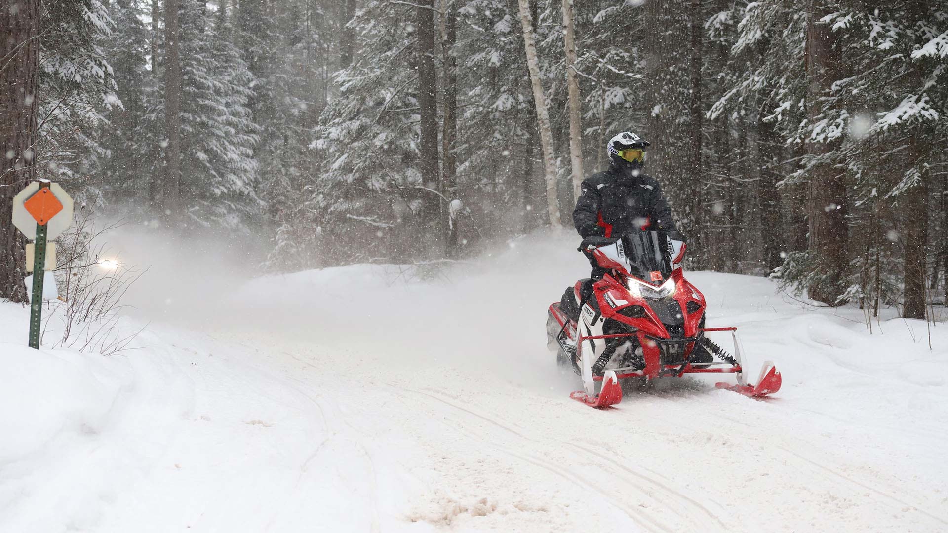 Snowmobile winding around the corner of the trail