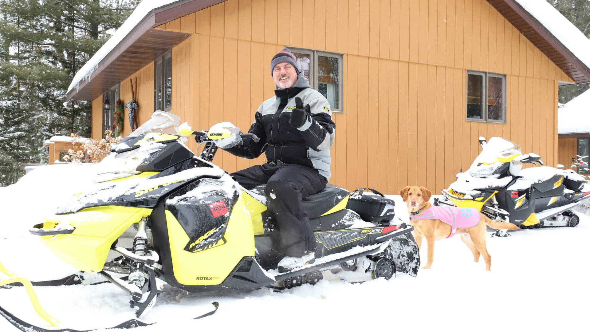 Man on snowmobile with dog at Wildcat Cabins in Boulder Junction Wisconsin