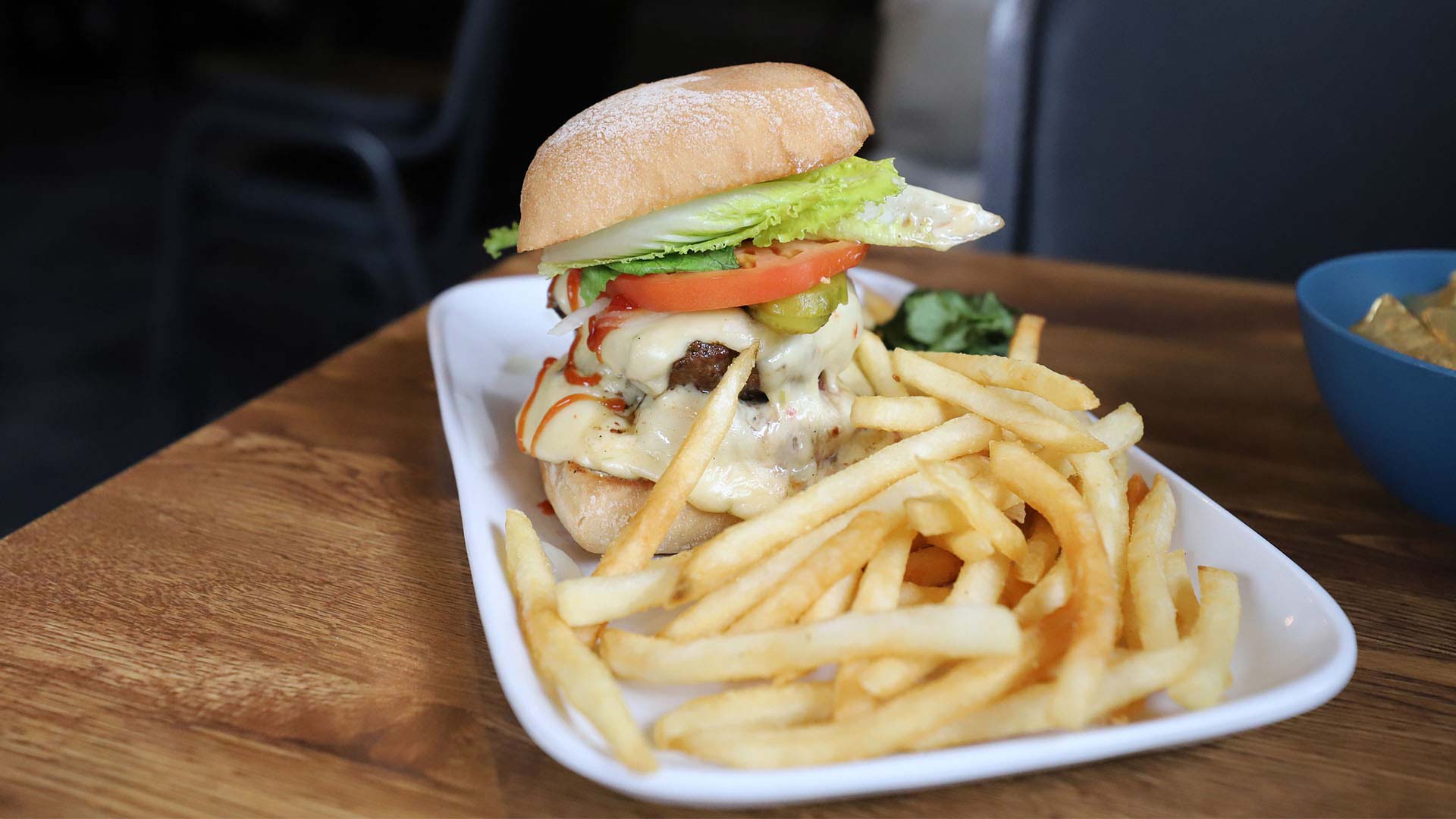 A big burger and a side of fries on a plate at Gooch's